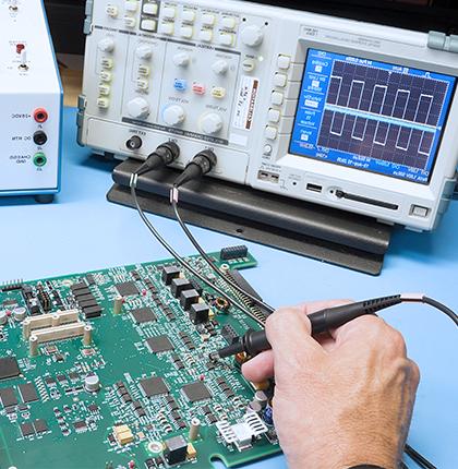 Close-up of a hand testing an application-specific integrated circuit